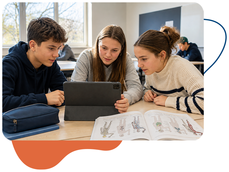 Drei Schülerinnen und Schüler arbeiten gemeinsam an einem Laptop. Neben ihnen liegt ein Schulbuch.